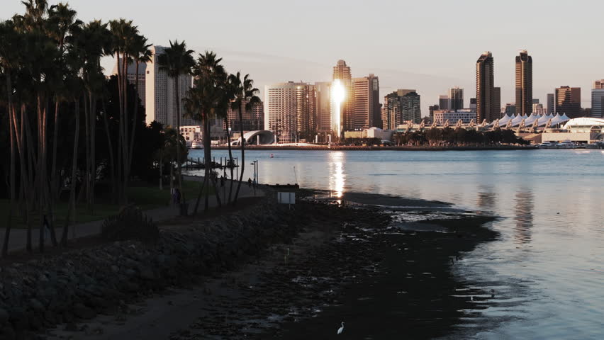 Aerial: Scenic Shot Of Modern Buildings In City, Drone Flying Forward Over Bay During Sunset - San Diego, California