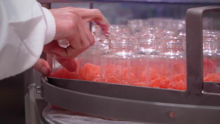 Pharmaceutical employee on an industrial quality control ckecking the production of nutraceutical gummies on the factory