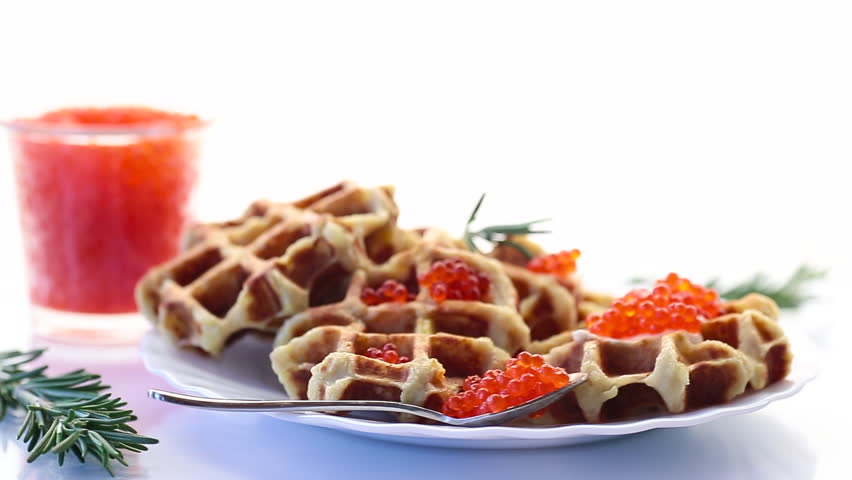 Potato waffles with red caviar on a white background