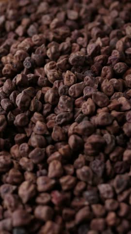 Raw Dark Brown Chickpeas (Kala Chana) on a rustic wooden table. Dry Balck chickpea (ceci neri) background close up.