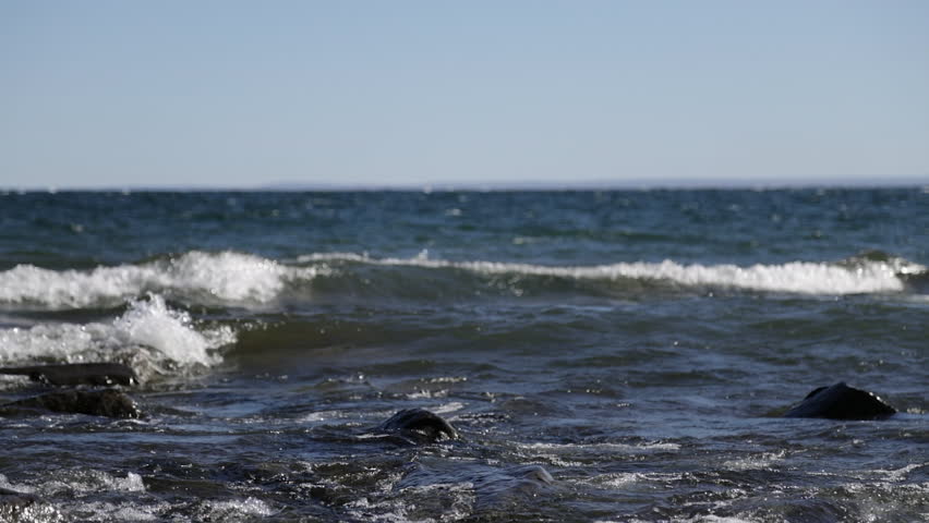 Big slow motion waves rolling into rocky shore in early evening, Lake Superior, Duluth, Minnesota, United States