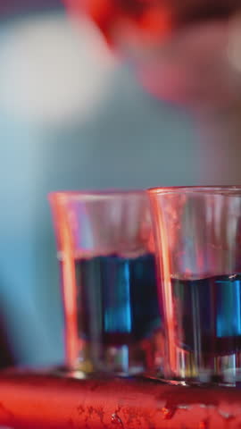 Barman prepares party shots in nightclub closeup. Barkeeper makes shooter sets pouring alcoholic drinks for party guests. Hard drink for celebrations