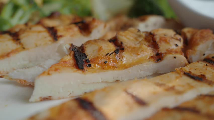 Grilled chicken preparation at outdoor barbecue gathering