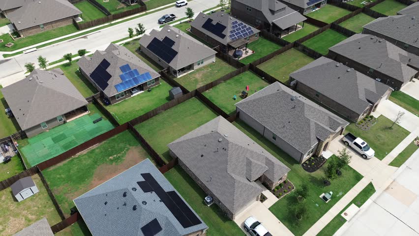 Brand new two-story suburban houses with solar panel roofs in rapid growing Princeton, Collin County, North Texas, clean energy efficiency home suburb DFW metroplex, large backyard, wooden fence. USA