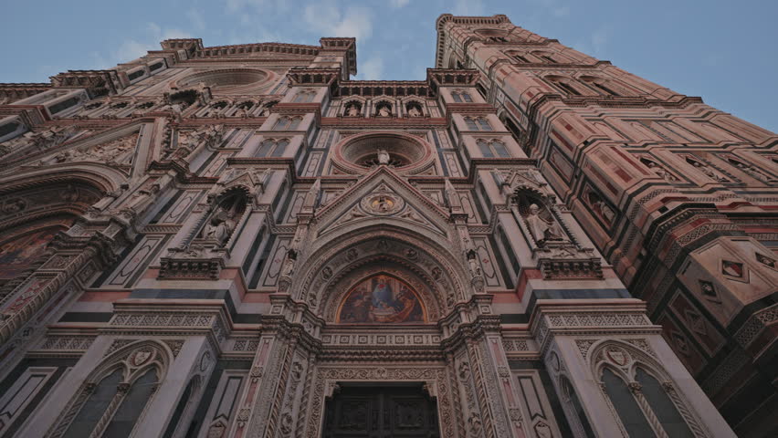 FLORENCE, ITALY - AUGUST 15 2024: Duomo Santa Maria del Fiore facade with Christian saints icons and statues under blue sky. Gorgeous Cathedral of St Mary with flower temple in ancient town