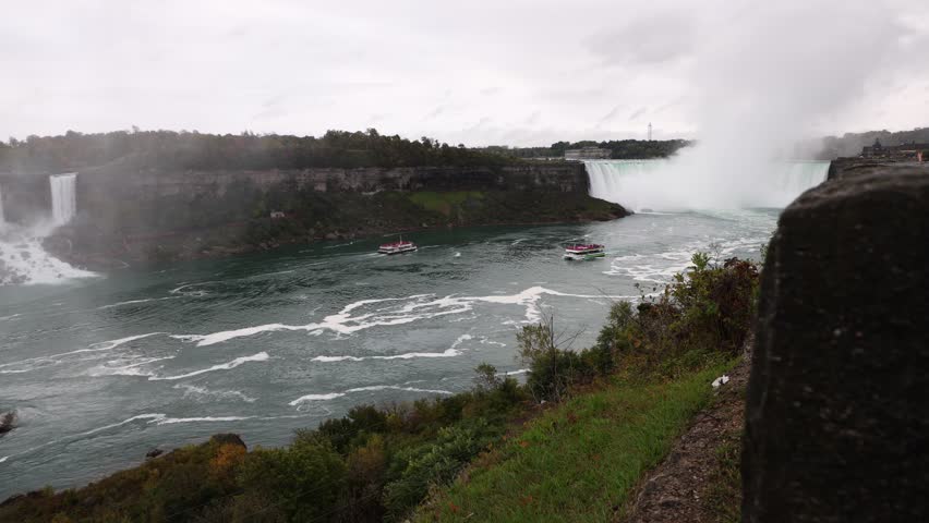 Niagara Falls with tour boats sailing along the river in Ontario, Canada