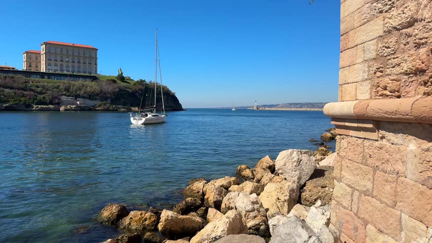 Rocky coastline with Palais du Pharo and sailboats in Marseille France