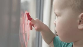 A young and imaginative child joyfully expresses their creativity by drawing a colorful heart on a window - Powered by Shutterstock - Get 15% off with code: PIKWIZARD15