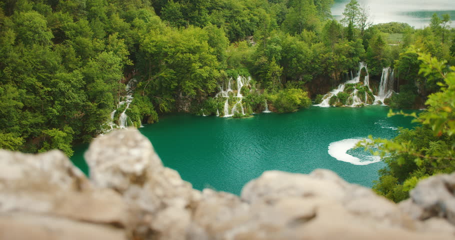 Stunning waterfalls plunge into a vivid turquoise lake at Plitvice Lakes National Park in Croatia summer