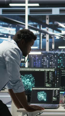 Vertical video Data center engineering team uses artificial intelligence deep learning models to configure gear. Teamworking colleagues work on AI programming language in server farm, optimizing
