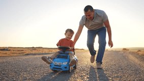 Father teaches his son how to drive a car. Family boy together concept. Father and child play with a toy car on the asphalt. Father takes his son for a ride in a toy car lifestyle on the asphalt -. - Powered by Shutterstock - Get 15% off with code: PIKWIZARD15