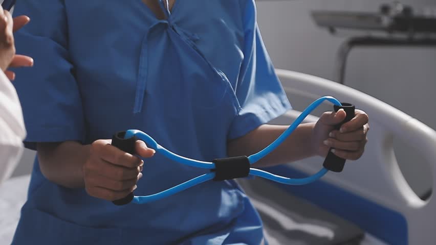 Physical therapist working with patient on upper extremity exerc