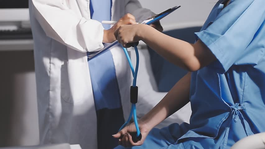 Physical therapist working with patient on upper extremity exerc