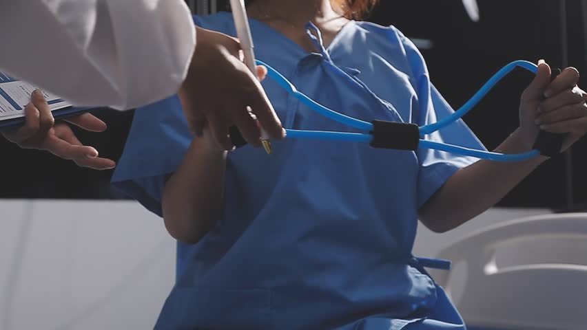 Physical therapist working with patient on upper extremity exerc