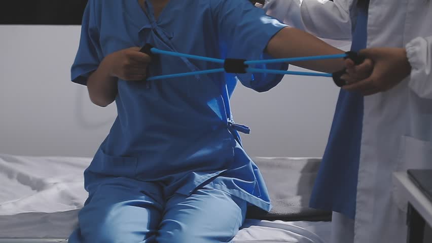 Physical therapist working with patient on upper extremity exerc