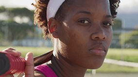 Female athlete holding bat on shoulder with gradient bars overlaying sports tech design. Athlete, sportswear, dynamic, energetic, outdoor, determination, modern - Powered by Shutterstock - Get 15% off with code: PIKWIZARD15