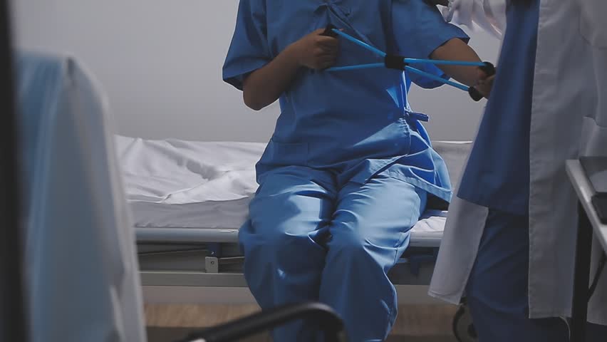 Physical therapist working with patient on upper extremity exerc