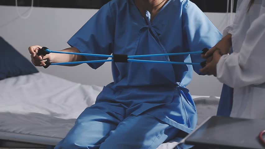 Physical therapist working with patient on upper extremity exerc