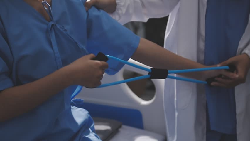 Physical therapist working with patient on upper extremity exerc