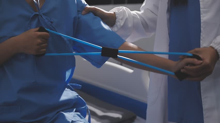 Physical therapist working with patient on upper extremity exerc