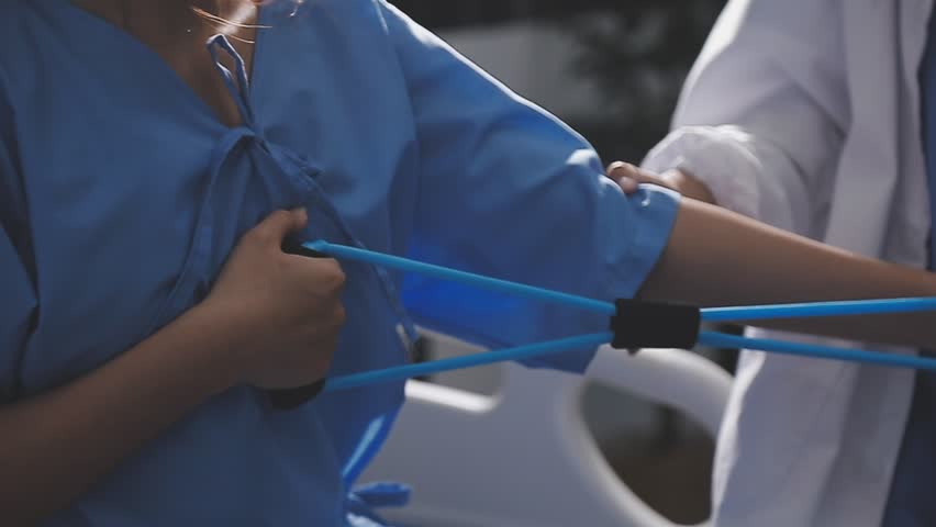 Physical therapist working with patient on upper extremity exerc