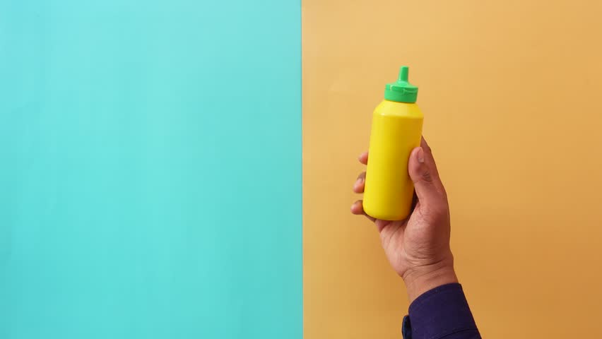 A Bright and Vibrant Mustard Bottle Set Against a Colorful Background
