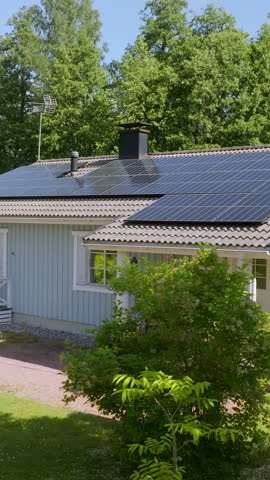 Vertical drone shot in front of a renewable energy powered house, summer day