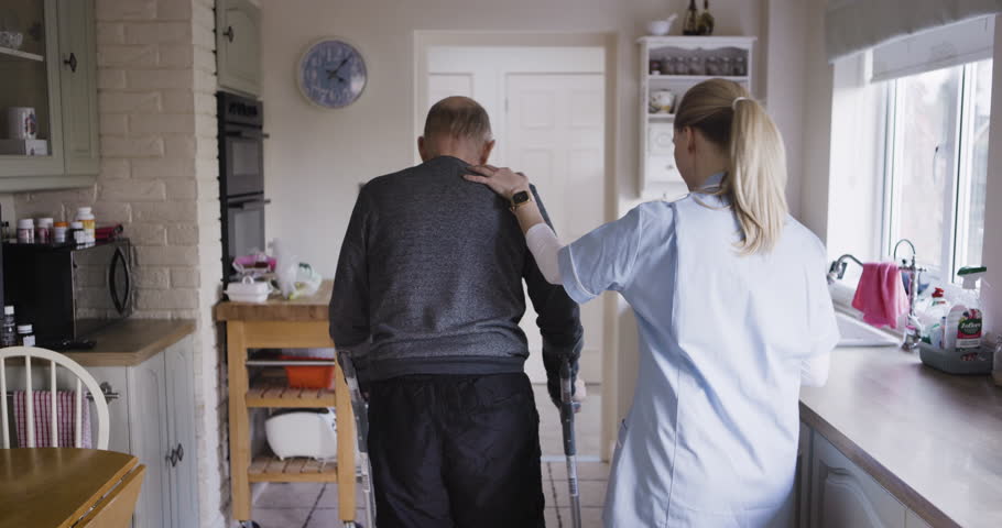Disability, help and doctor with a senior man for medical support, physiotherapy and healthcare in a house. Nurse, physiotherapist or caregiver helping an elderly man with walking and rehabilitation