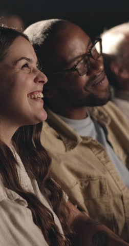Laugh, movie and happy couple in cinema audience for premiere and entertainment. Theatre, interracial people and comedy or joke of show, performance and watching film with partner, spectator and fun