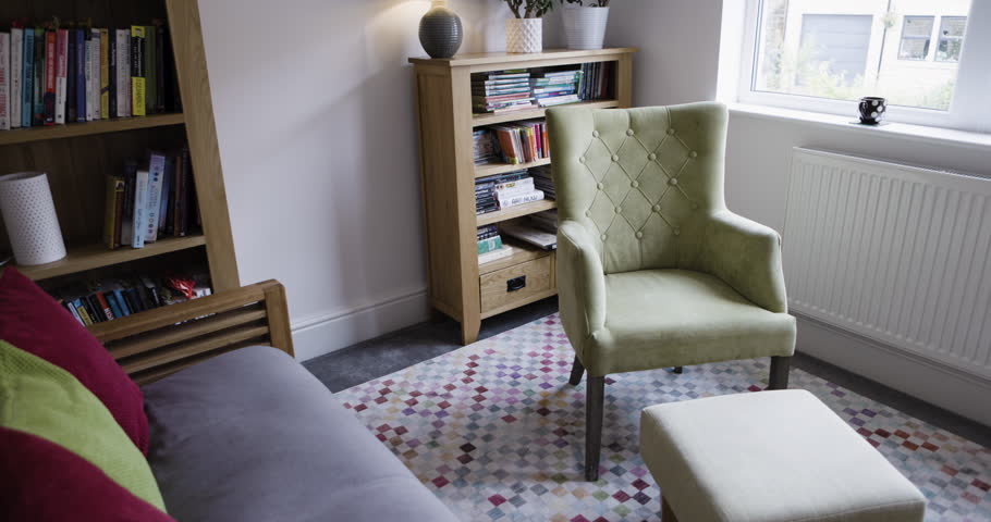 Living room, house and furniture in room for luxury and comfort for real estate, interior design or renovation mockup. Hotel, hospitality and show house background with chair, window and bookshelf