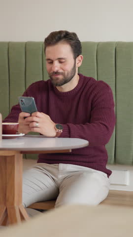 Relax, laughing or happy man in cafe with phone for online review, text message and social media chat. Restaurant menu, smile and customer in coffee shop with mobile for break, funny joke or meme