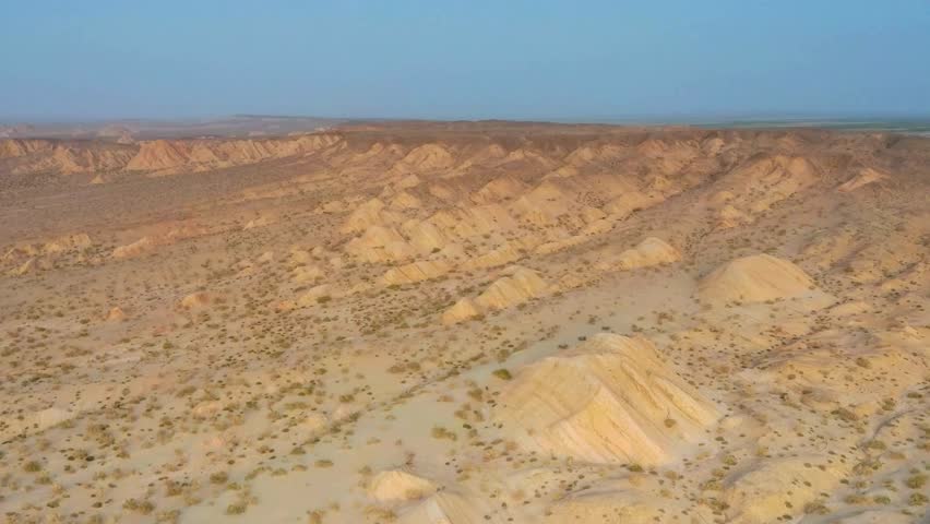 Aerial View of Desert Landscape with Eroded Hills and Sparse Vegetation
