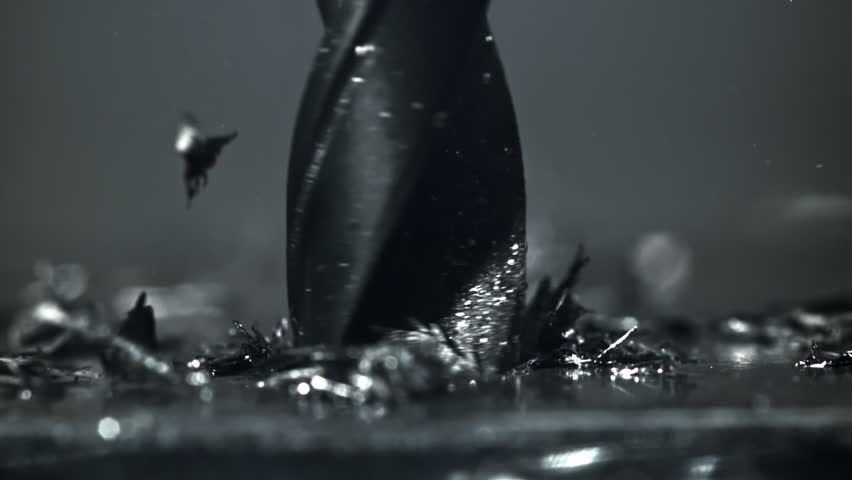 Drilling metal with flying chips and smoke. Filmed on a high-speed camera at 1000 fps. High quality FullHD footage