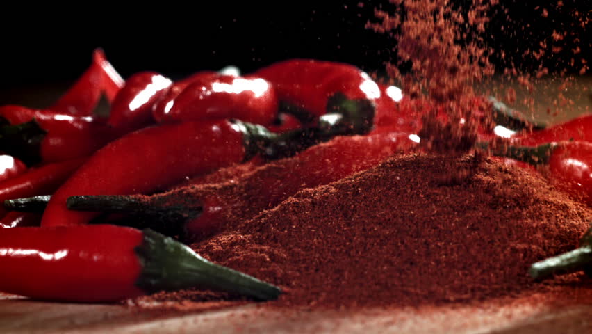 Ground red pepper falls on the table. Filmed on a high-speed camera at 1000 fps. High quality FullHD footage