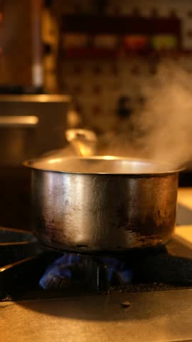 A Boiling Pot on a Gas Stove Located Inside a Cozy Kitchen Space