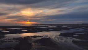 Tidal pool reflections and fishermen with setting sun. Lateral flight. Fleetwood, Lancashire, UK - Powered by Shutterstock - Get 15% off with code: PIKWIZARD15