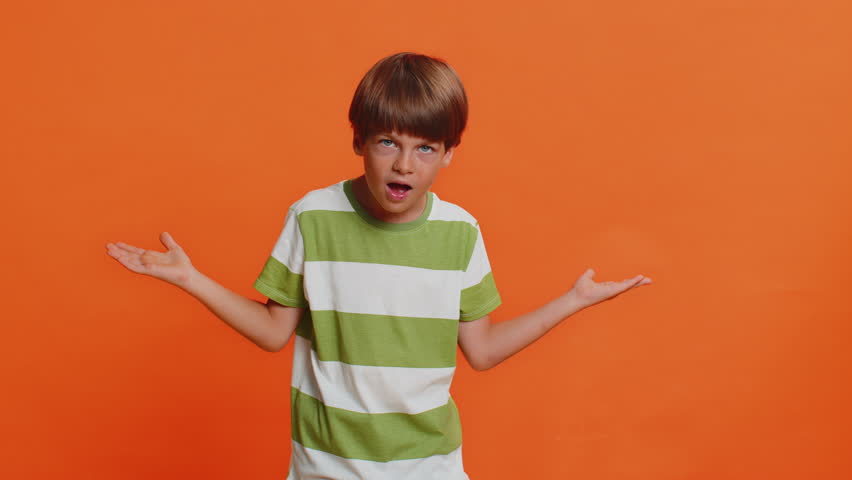 I don't know what to say. Confused preteen child boy kid feeling embarrassed about ambiguous question, having doubts, no answer, idea, being clueless, uncertain. Little children on orange background