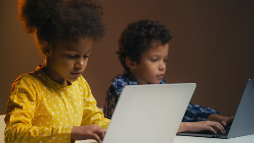 African American girl and boy typing on laptops for school project, teamwork - Powered by Shutterstock - Get 15% off with code: PIKWIZARD15