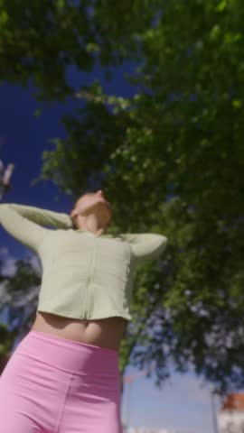 Energetic and Vibrant Young Woman Joyfully Embracing Nature While Wearing Stylish Activewear