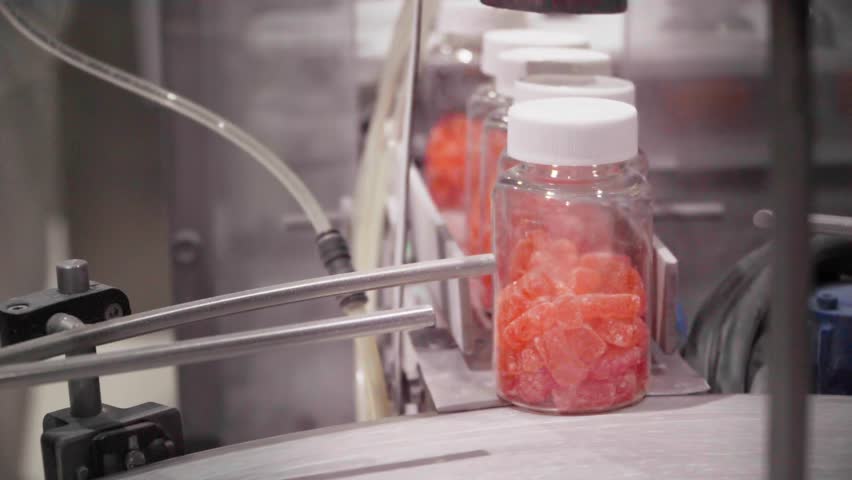 Jars with nutraceutical gummies on the factory production line