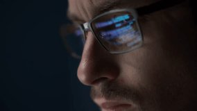 Close up of serious software engineer wearing glasses looks at his screen, with code reflecting on his eyeglasses. Coder is focused on programming, data analysis, or cybersecurity - Powered by Shutterstock - Get 15% off with code: PIKWIZARD15