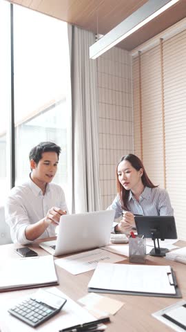 A positive work environment shines through as a smiling businesswoman engages with her team, using her laptop to support corporate communication and teamwork