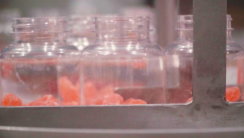Jars with nutraceutical gummies on the factory production line