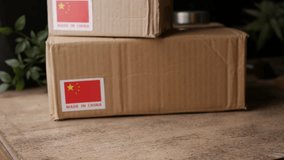 Man Hands carry shipping cardboard box with MADE IN China flag label on. - Powered by Shutterstock - Get 15% off with code: PIKWIZARD15