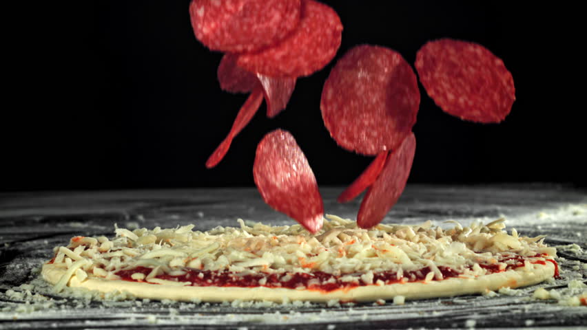 Making pizza. The salami sausage falls on the pizza. Filmed on a high-speed camera at 1000 fps. High quality FullHD footage