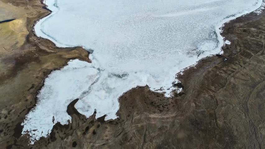 Aerial View of Glacial Ice Melting into Dark Earth