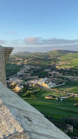 Gozo, Malta — view over the green fields and traditional countryside architecture on a clear December day. The peaceful rural landscape blends nature with Gozo’s timeless charm. DEC 2022