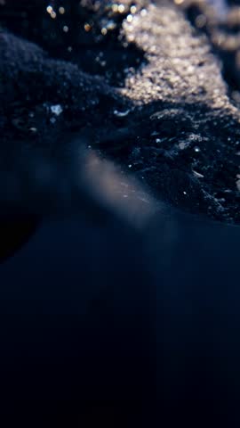 Divers performing safety stop underwater before ascending near dive boat