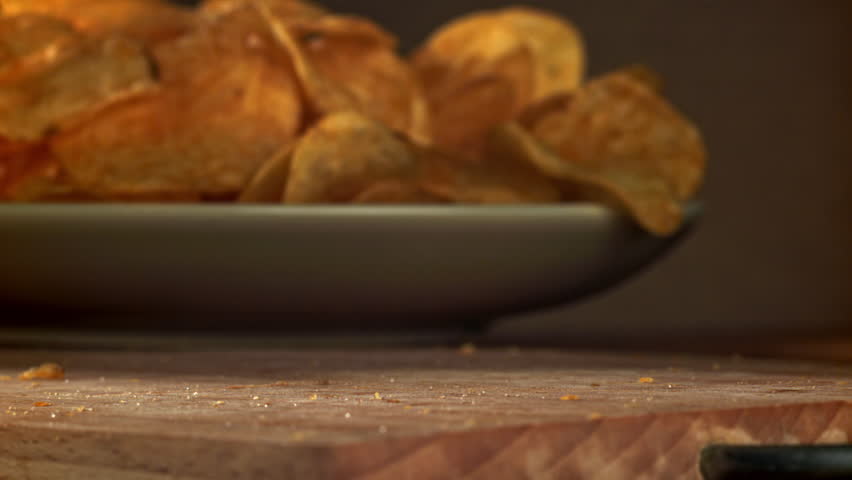 Potato chips fall on a wooden table. Filmed on a high-speed camera at 1000 fps. High quality FullHD footage