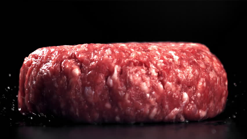 A fresh meat burger falls on a black table. Filmed on a high-speed camera at 1000 fps. High quality FullHD footage